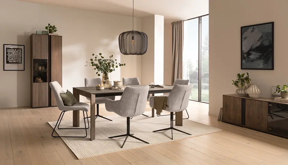 Helles Esszimmer mit großem Holztisch, grauen Polsterstühlen und stilvoller Pendelleuchte, kombiniert mit Holzvitrine und Sideboard, schafft ein modernes und gemütliches Wohnambiente mit natürlichem Design.